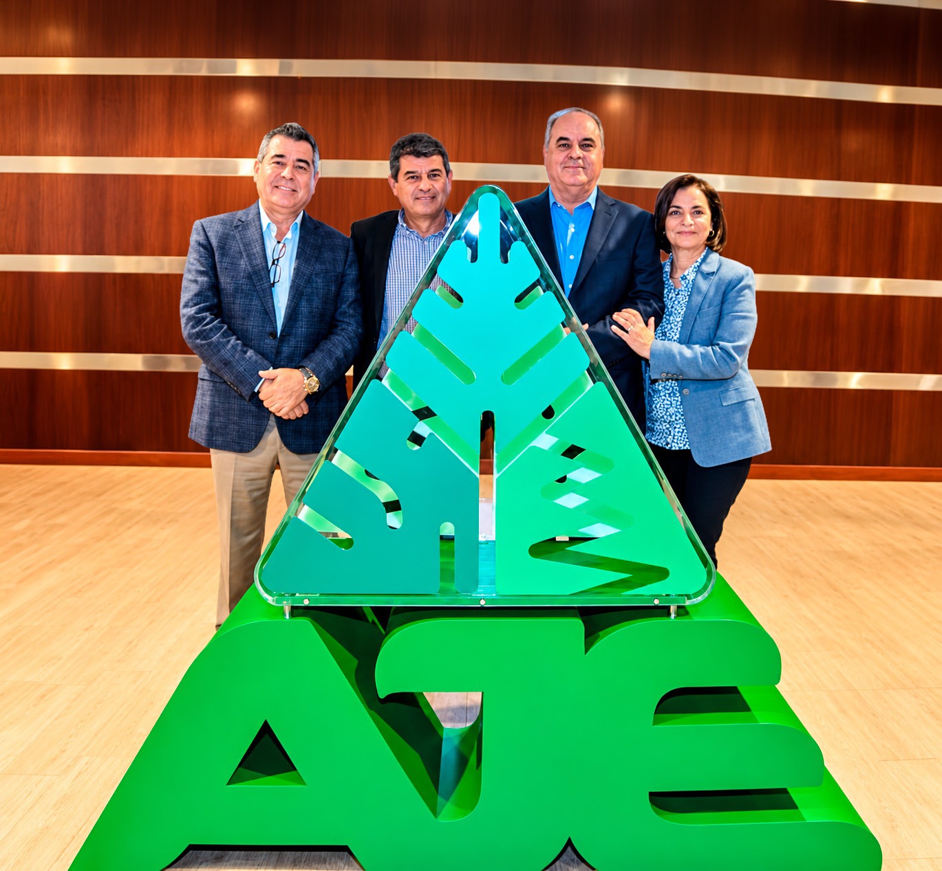 Equipo AJE junto al símbolo del árbol de la compañía